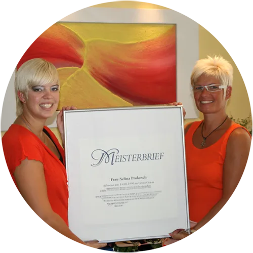 Selina und Maike halten zusammen den eingerahmten Meisterbrief von Selina